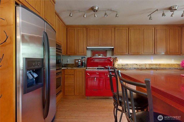 18 Blue Creek Rd, Walla Walla, WA 99362 - kitchen featuring stainless steel fridge with ice dispenser, light wood-type flooring, brown cabinets, under cabinet range hood, and light stone counters