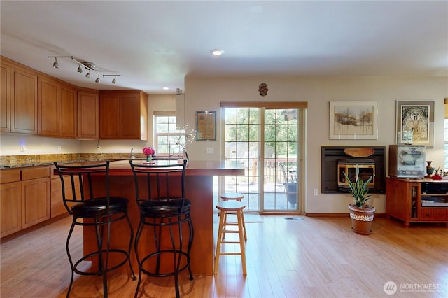 18 Blue Creek Rd, Walla Walla, WA 99362 - kitchen featuring light wood-style floors, a kitchen bar, a kitchen island, brown cabinetry, and recessed lighting