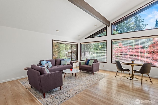 living area with beamed ceiling, light wood-type flooring, plenty of natural light, baseboards, and recessed lighting
