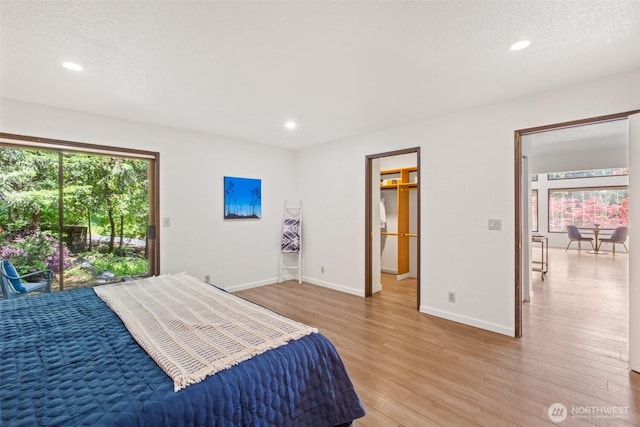 bedroom with multiple windows, light wood finished floors, recessed lighting, and baseboards