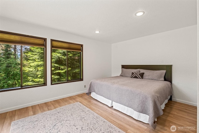 bedroom featuring wood finished floors, baseboards, and recessed lighting