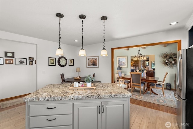 55771 Mossyrock Ave, Mossyrock, WA 98564 - kitchen with freestanding refrigerator, light wood finished floors, a chandelier, a center island, and recessed lighting