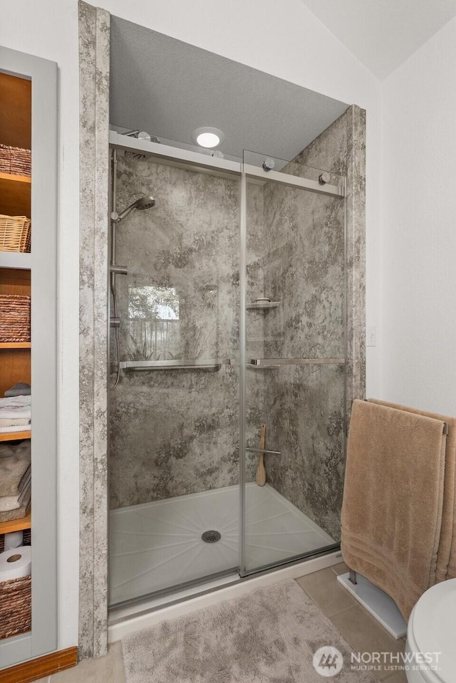55771 Mossyrock Ave, Mossyrock, WA 98564 - full bathroom featuring a shower stall, toilet, and tile patterned flooring