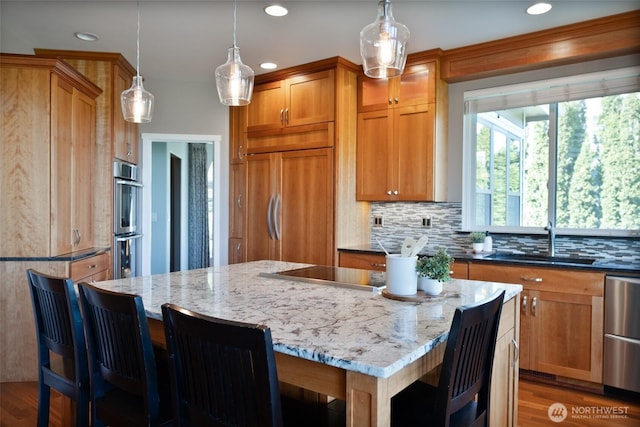 746 Van Dyk Rd, Lynden, WA 98264 - kitchen with a sink, light stone countertops, a kitchen island, appliances with stainless steel finishes, and brown cabinets
