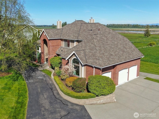 746 Van Dyk Rd, Lynden, WA 98264 - traditional-style house featuring brick siding, a shingled roof, asphalt driveway, a water view, and an attached garage