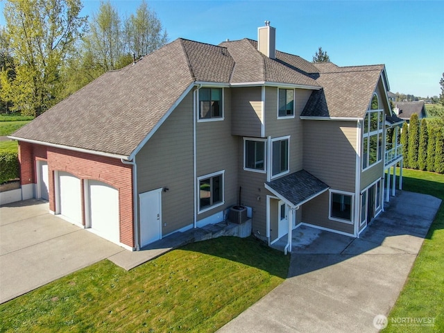 746 Van Dyk Rd, Lynden, WA 98264 - view of side of property featuring a chimney, driveway, a yard, a shingled roof, and central air condition unit