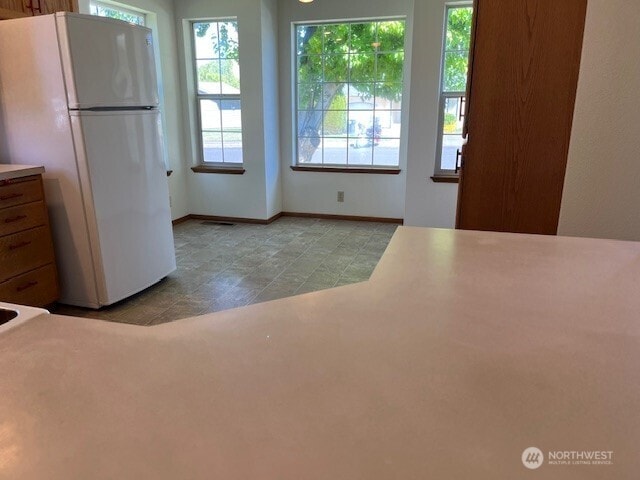 434 SE Stanford Pl, College Place, WA 99324 - kitchen featuring freestanding refrigerator, plenty of natural light, and baseboards