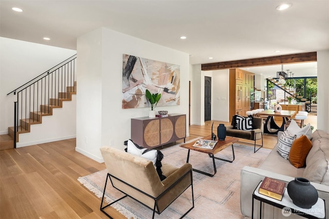 living area with light wood-type flooring, stairway, recessed lighting, and baseboards