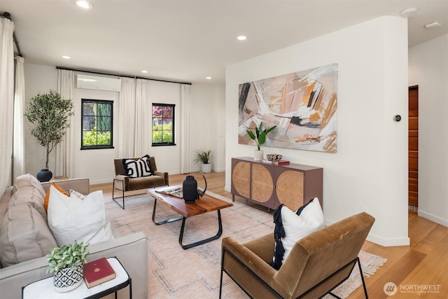 living area with a wall unit AC, light wood-type flooring, recessed lighting, and baseboards
