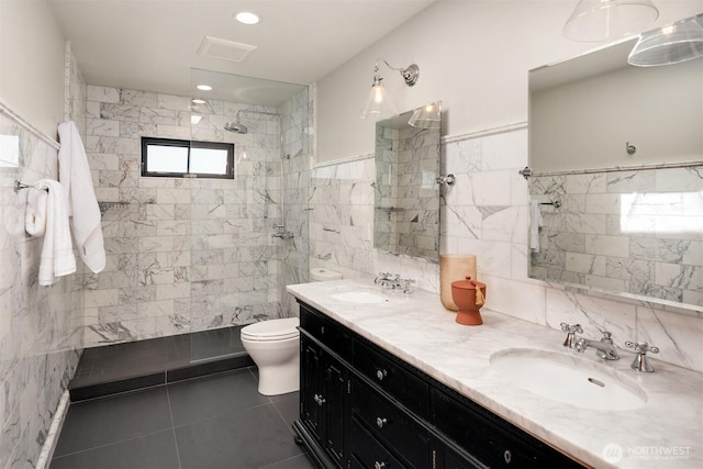 bathroom featuring tile walls, tile patterned floors, toilet, walk in shower, and double vanity