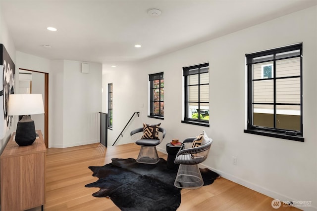 misc room with wood finished floors, recessed lighting, baseboards, and an upstairs landing
