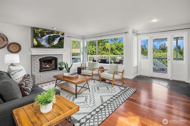 living area featuring wood finished floors, a fireplace, recessed lighting, and baseboards