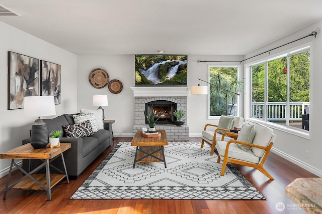 living area with wood finished floors, baseboards, and a fireplace