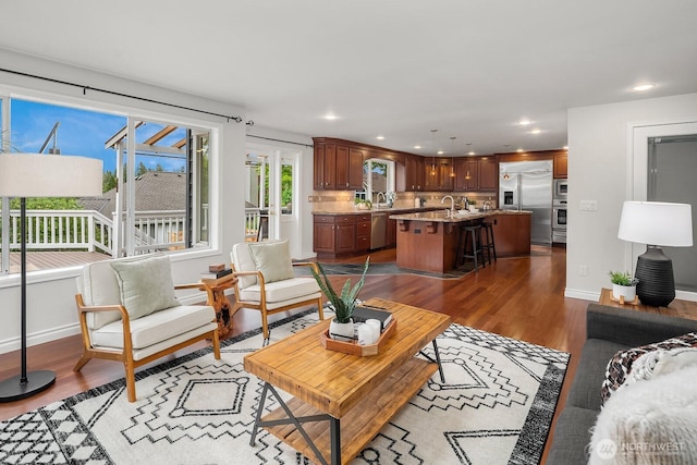 living area with dark wood-style floors, baseboards, and recessed lighting