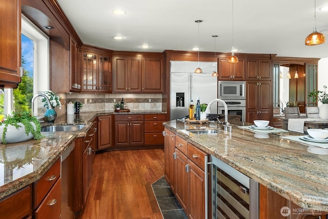 kitchen with a sink, built in appliances, beverage cooler, dark wood-style floors, and recessed lighting