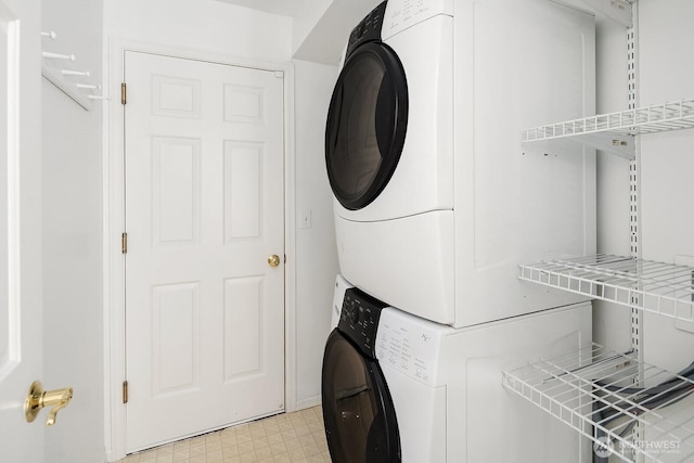 laundry room featuring stacked washer / dryer and light flooring