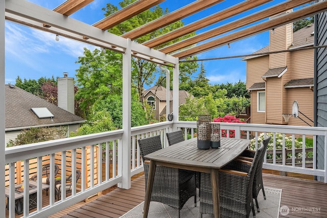 wooden terrace with a pergola and outdoor dining area