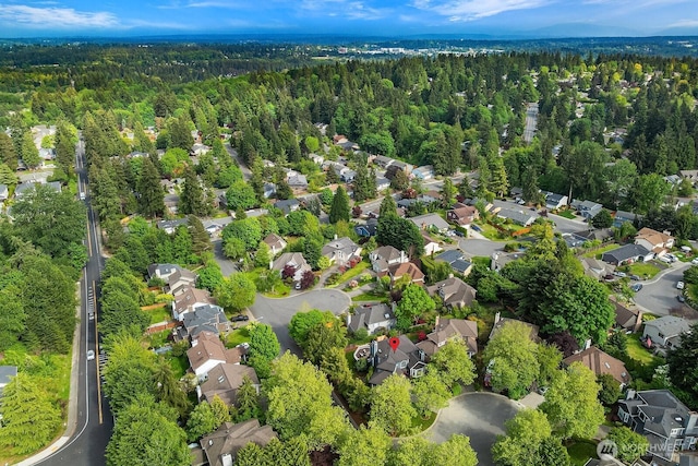 view of property location featuring a heavily wooded area and nearby suburban area