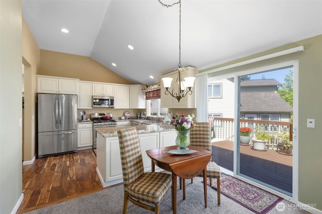 9619 Windswept Ln NW, Silverdale, WA 98383 - kitchen with stainless steel appliances, a chandelier, a peninsula, dark wood-type flooring, and vaulted ceiling