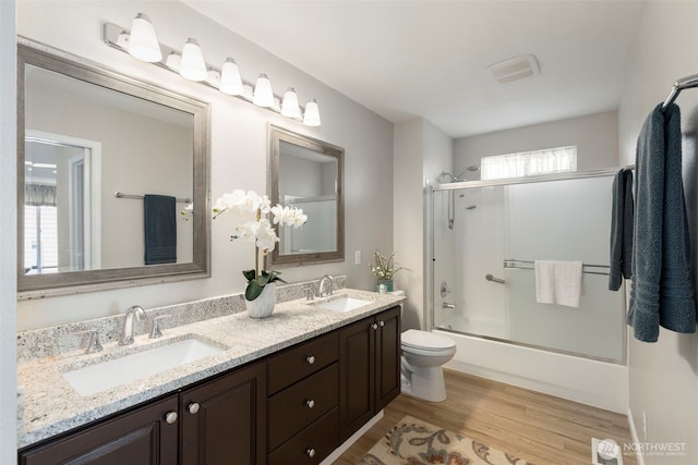9619 Windswept Ln NW, Silverdale, WA 98383 - bathroom with double vanity, wood finished floors, and bath / shower combo with glass door