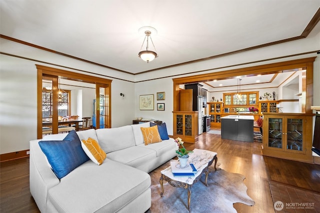 living area featuring dark wood-type flooring, plenty of natural light, crown molding, and french doors