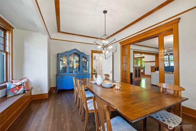 dining room featuring dark wood-style floors, a chandelier, crown molding, and baseboards