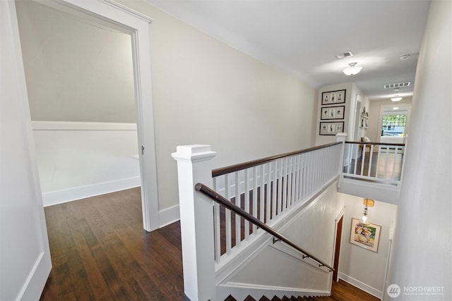 stairway with wood finished floors and baseboards