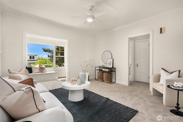 carpeted living area featuring a ceiling fan, crown molding, and baseboards