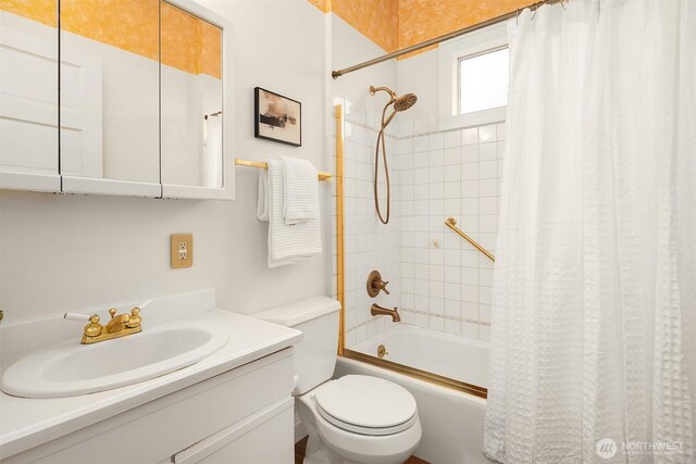 bathroom with shower / tub combo with curtain, toilet, and vanity
