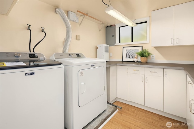 washroom featuring washer and dryer, cabinet space, and light wood finished floors