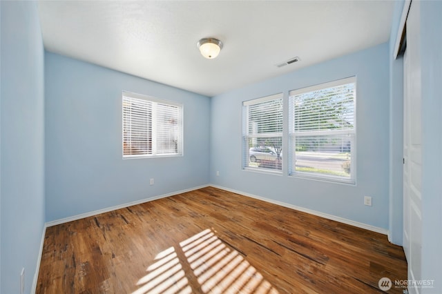 empty room with baseboards and wood finished floors