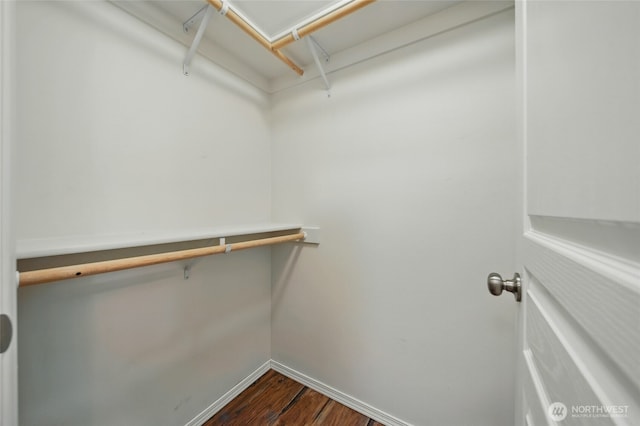spacious closet with dark wood-style flooring and attic access