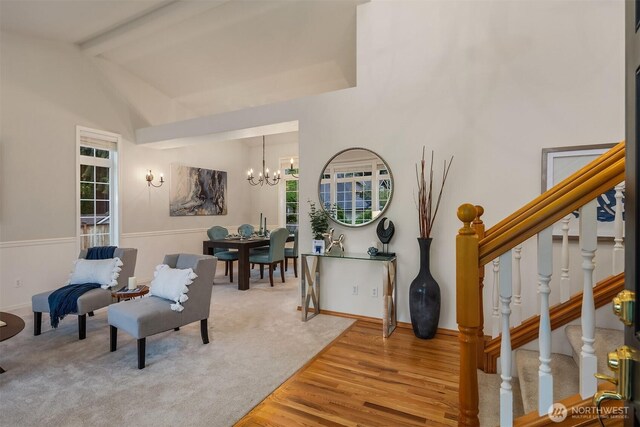 sitting room featuring a chandelier, stairs, healthy amount of natural light, and wood finished floors