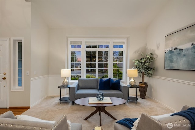 carpeted living room with healthy amount of natural light and baseboards