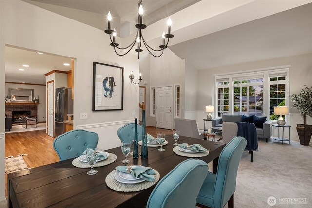dining space featuring a chandelier and a brick fireplace