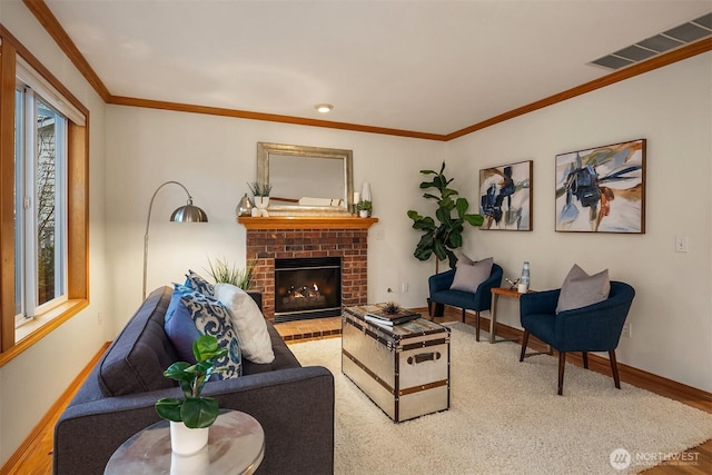 living room with wood finished floors, baseboards, a brick fireplace, and crown molding