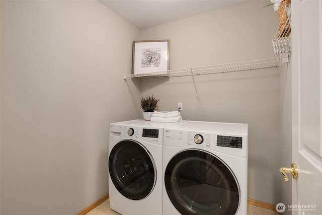 laundry area with independent washer and dryer and baseboards