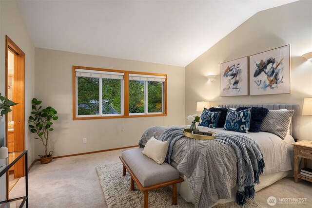 bedroom with vaulted ceiling, light colored carpet, and baseboards