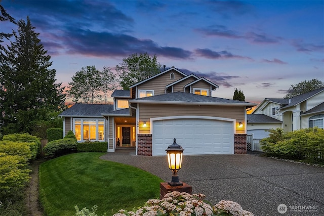 traditional-style house featuring driveway, an attached garage, brick siding, and a front lawn