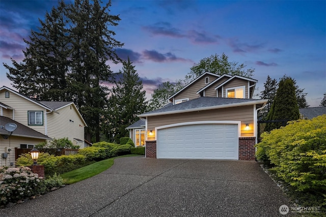 view of front of house featuring driveway, brick siding, and an attached garage