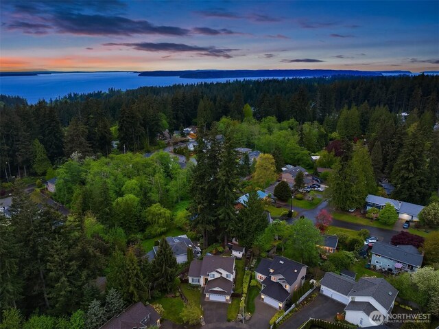 aerial view at dusk of a view of trees, a water view, and a residential view
