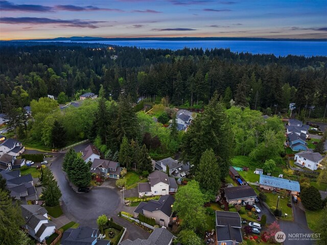 aerial view at dusk of a wooded view and a residential view