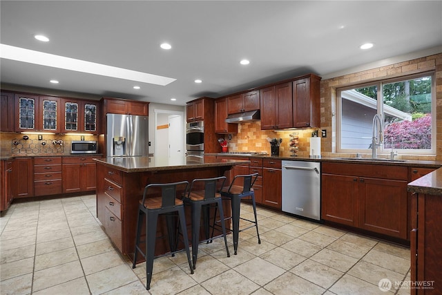 1120 Maple Valley Rd SW, Olympia, WA 98512 - kitchen with appliances with stainless steel finishes, a sink, tasteful backsplash, a kitchen island, and a breakfast bar area