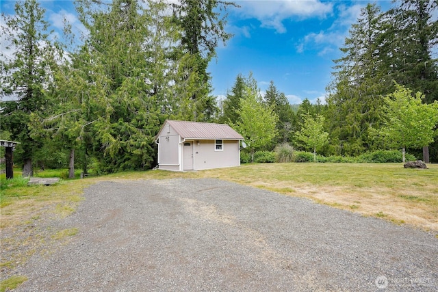 1120 Maple Valley Rd SW, Olympia, WA 98512 - garage featuring a storage shed, a view of trees, and driveway