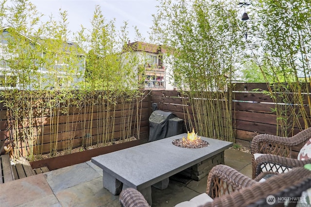view of patio / terrace featuring a grill, an outdoor fire pit, and a fenced backyard