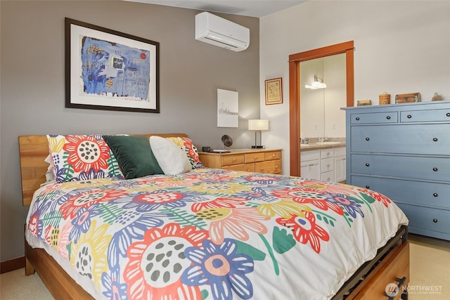 bedroom featuring a wall unit AC, ensuite bath, and a sink