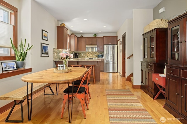 dining space featuring light wood-style floors, recessed lighting, and stairway