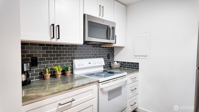 kitchen featuring stainless steel microwave, electric range, decorative backsplash, and white cabinetry