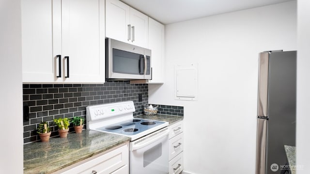 kitchen featuring appliances with stainless steel finishes, white cabinets, backsplash, and dark stone countertops