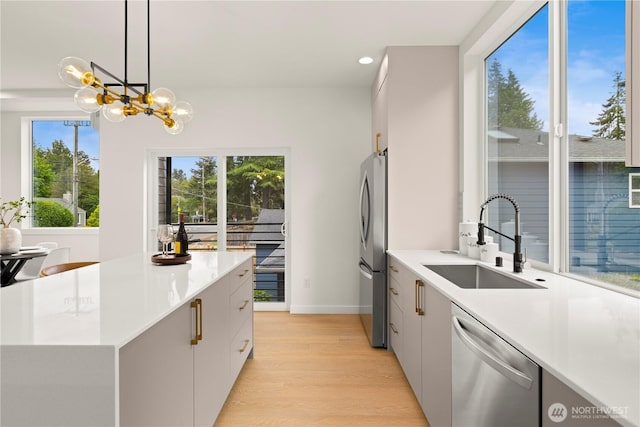 1911C N 120th St, Seattle, WA 98133 - kitchen with stainless steel appliances, a sink, light wood-style floors, light countertops, and recessed lighting